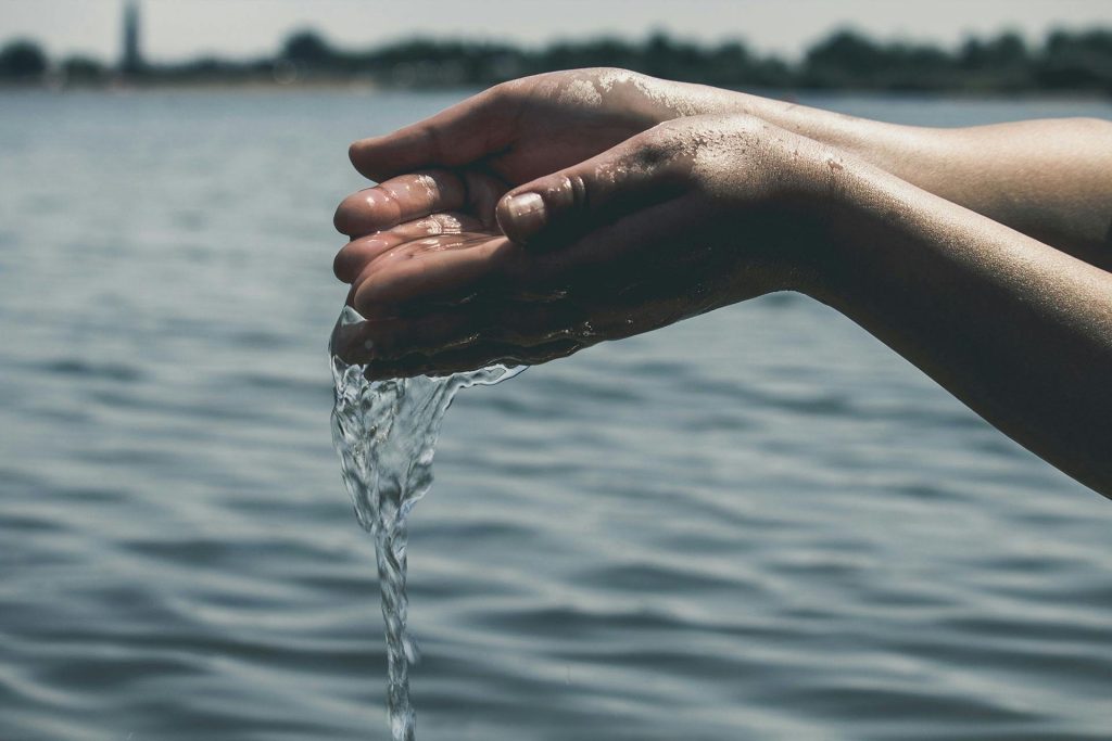 Taufe Symbol: Hand mit Wasser für christliche Taufzeremonie